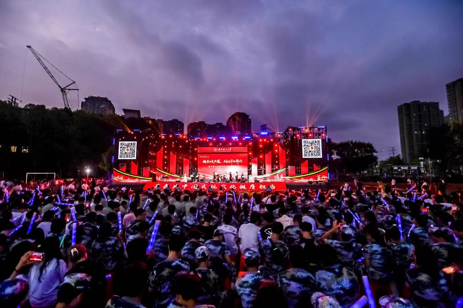 A large campus gala audience facing a lit stage